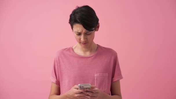 Displeased Asian Man Texting Phone Pink Studio — Vídeo de Stock