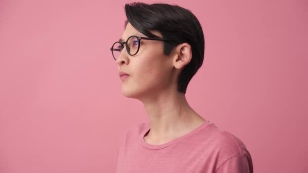 深刻なアジアの男で眼鏡の中にカメラでザ ピンクのスタジオ — ストック動画