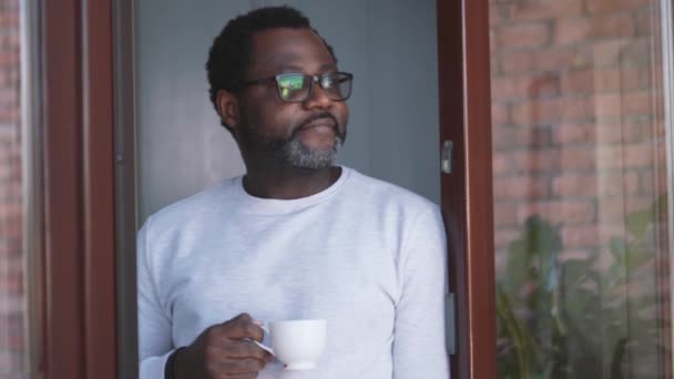 Hombre Africano Positivo Mirando Vista Beber Café Cerca Ventana — Vídeos de Stock
