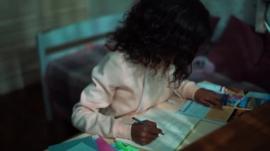 Serious African young girl doing homework at home