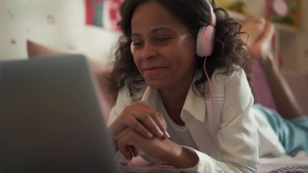Happy African Young Girl Headphones Watching Something Laptop Home — стоковое видео