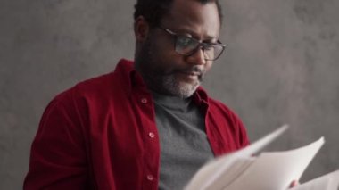 Serious African man working with papers in office