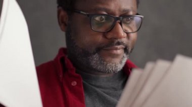 Concentrated African man working with papers in office