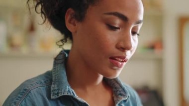 Positive African woman barista positively shaking her head in cafe