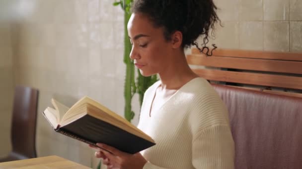 Serious African Woman Reading Book Cafe — Vídeos de Stock