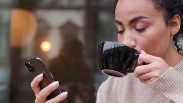 Positive African Woman Drinking Coffee Typing Mobile Outdoors — Video