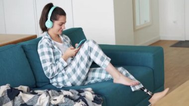 Yapay biyonik yüksek teknolojili bacak protezi olan mutlu kadın evde telefonla mesaj atıyor.