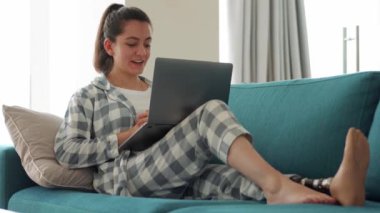 Suni biyonik yüksek teknolojili gülümseyen kadın bacak protezi evdeki bilgisayardan video ile konuşuyor.