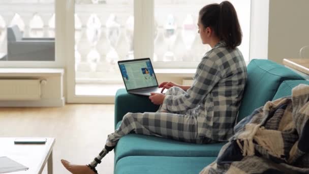 在家里笔记本电脑上工作的漂亮女人 有人造仿生高科技假腿 — 图库视频影像