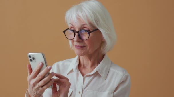 Mulher Madura Positiva Camisa Branca Mensagens Texto Por Telefone Estúdio — Vídeo de Stock