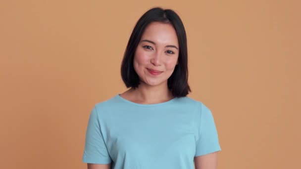 Mulher Sorridente Camiseta Azul Olhando Para Câmera Estúdio Bege — Vídeo de Stock