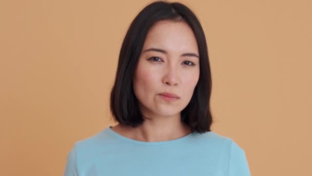 Mavi Tişörtlü Kızgın Kadın Kameraya Bakıyor Bej Stüdyoda Sessizlik Jesti — Stok video