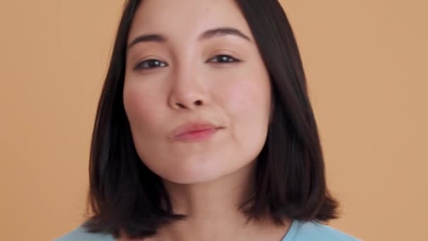 Mavi Tişörtlü Gülümseyen Kadın Bej Stüdyodaki Kamerada Yüzüne Bakıyor — Stok video