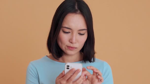 Emotional Woman Blue Shirt Typing Phone Beige Studio — Stock Video