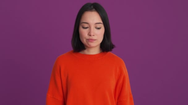 不満な女性で赤いセーターショー何とかジェスチャーでザ紫スタジオ — ストック動画