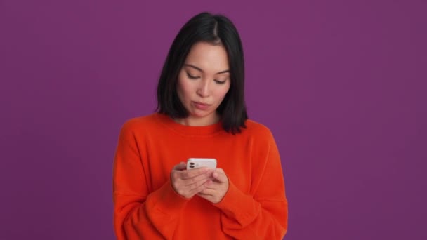 穿着红色毛衣的怒气冲冲的女人在紫色工作室打电话 — 图库视频影像