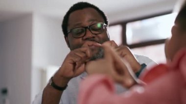 Gözlüklü mutlu Afrikalı adam kızına kalp şeklinde bir jest yapıyor.
