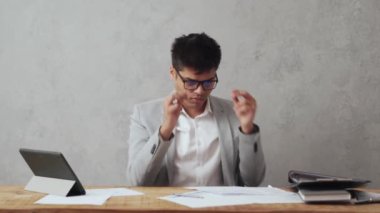 Ofiste kağıt işiyle uğraşan pozitif Hintli işadamı