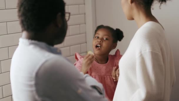 Feliz Niña Africana Comiendo Pepino Hablando Con Sus Padres Cocina — Vídeo de stock