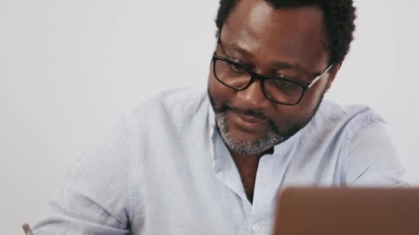 Ευτυχισμένος Αφρικανός Επιχειρηματίας Γράφει Κάτι Στο Χαρτί Στο Σπίτι — Αρχείο Βίντεο