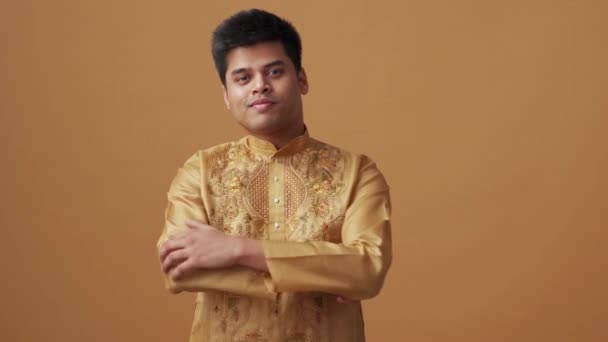 Ευτυχισμένος Ινδός Εθνικό Ύφασμα Κοιτάζοντας Την Κάμερα Στο Πορτοκαλί Στούντιο — Αρχείο Βίντεο