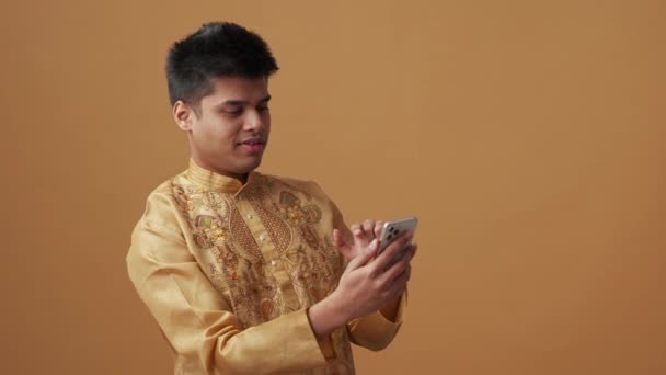 Homem Indiano Alegre Pano Nacional Olhando Para Telefone Estúdio Laranja — Vídeo de Stock