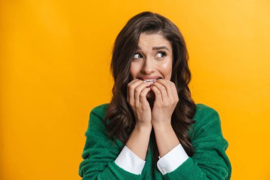 Kafası karışmış genç, düşünceli esmer bir kadının portresi sarı bir arka planda tek başına duruyor.