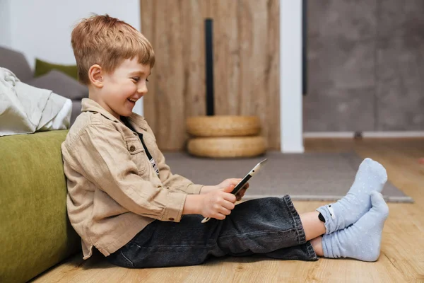 Happy Boy Maluch Gospodarstwa Tablet Podczas Siedzenia Salonie — Zdjęcie stockowe