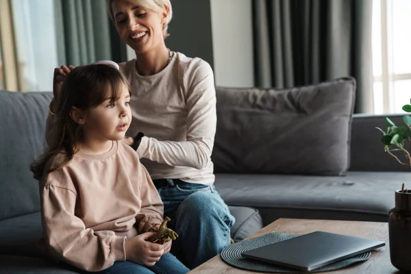 Gelukkig Jong Moeder Borstelen Haar Kleine Dochters Haar Terwijl Zitten — Stockfoto