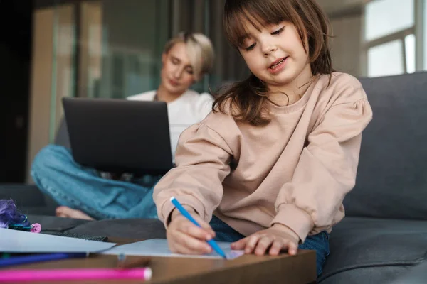 Genç Anne Anaokulu Kızı Oturma Odasında Annesi Dizüstü Bilgisayarla Çalışıyor — Stok fotoğraf