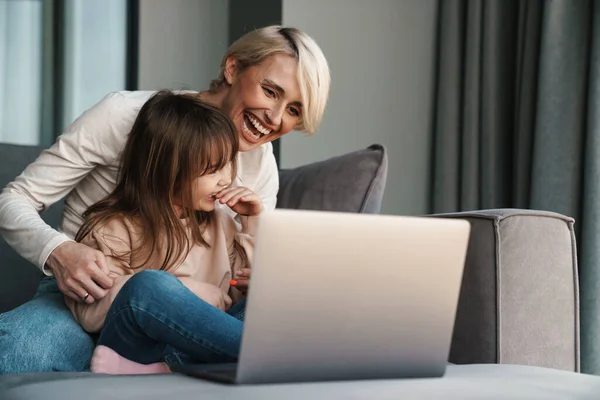 Щаслива Молода Мама Маленька Дочка Сидять Дивані Ноутбуком Дивлячись Екран — стокове фото