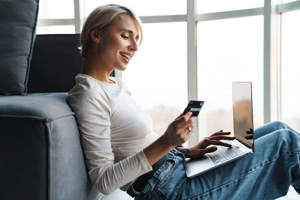 Uśmiechnięta Blondynka Średnim Wieku Zakupy Online Karty Kredytowej Laptopa Kanapie — Zdjęcie stockowe