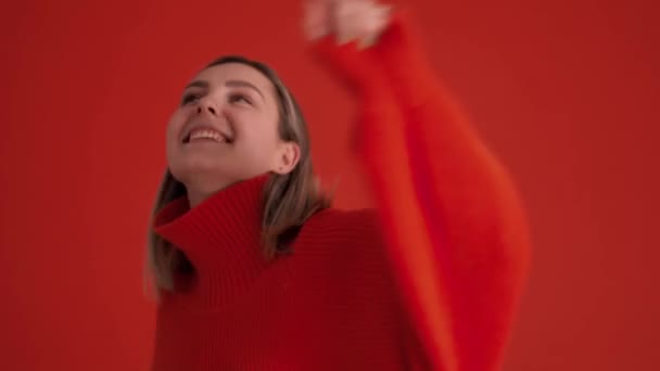 Glimlachende Vrouw Draagt Rode Trui Dansen Rode Studio — Stockvideo