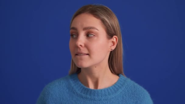 Mavi Süveter Giyen Yakışıklı Bir Kadın Etrafa Bakıyor Mavi Stüdyoda — Stok video