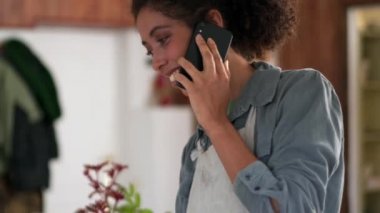 Evde telefonla konuşan yakışıklı Afrikalı kadın.