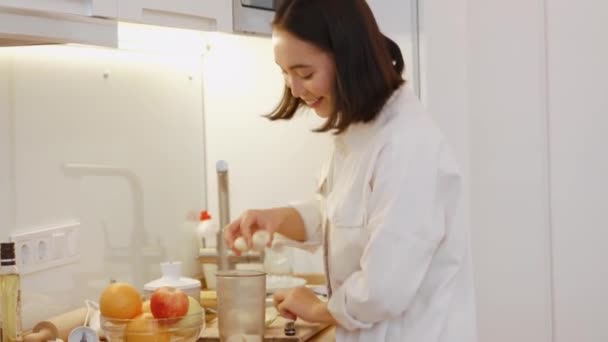 Lächelnde Asiatin Macht Bananen Milchshake Der Küche — Stockvideo