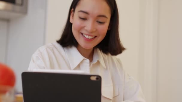 Sonriente Mujer Asiática Escribiendo Algo Hablando Por Videollamada Tableta Casa — Vídeo de stock