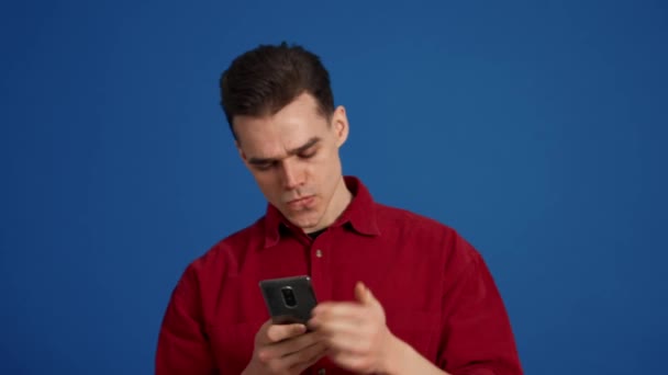 Homem Morena Emocional Folheando Fita Por Telefone Estúdio Azul — Vídeo de Stock