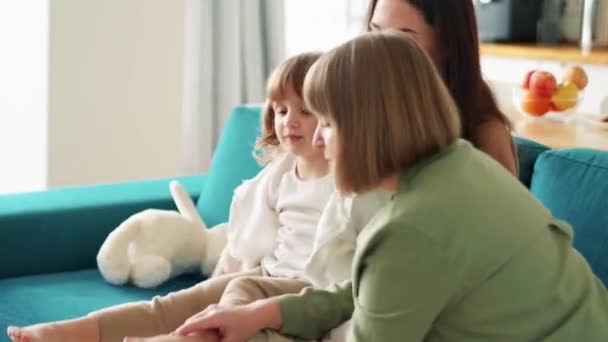 Glückliche Großmutter Knetet Ihrer Enkelin Auf Der Couch Die Füße — Stockvideo