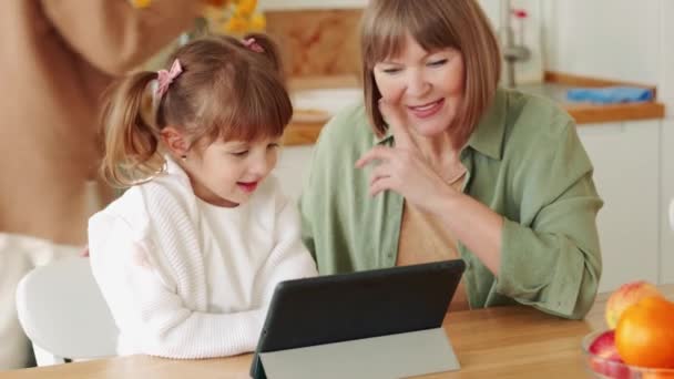 Sorrindo Avó Assistindo Algo Tablet Conversando Com Neta Cozinha — Vídeo de Stock