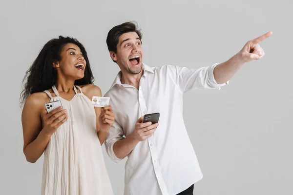 Mann Und Frau Posieren Aufgeregt Mit Mobiltelefonen Und Kreditkarte Isoliert — Stockfoto