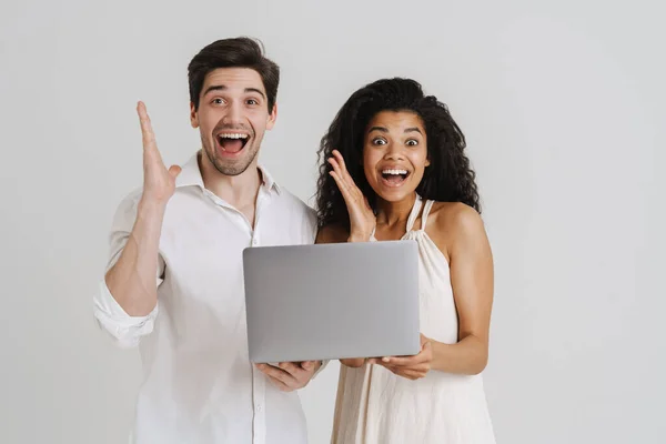 多种族兴奋的夫妇 拿着笔记本电脑 在白色背景下孤身一人尖叫 — 图库照片