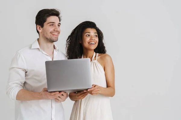多种族兴奋的一对情侣 带着笔记本电脑 面带微笑 与白色背景隔离 — 图库照片