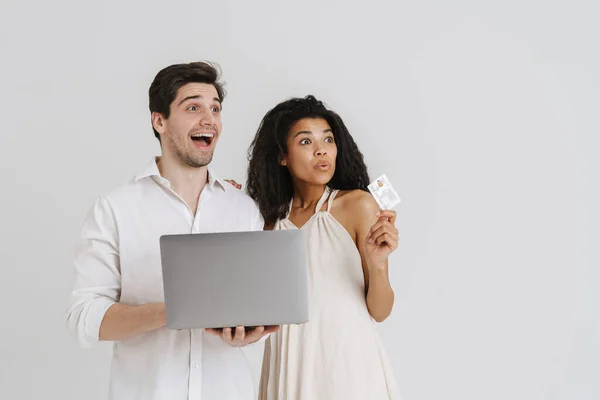 Wielorasowy Podekscytowany Para Pozowanie Laptopem Kartą Kredytową Izolowane Białym Tle — Zdjęcie stockowe
