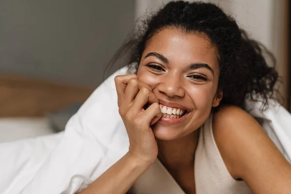 Счастливая Молодая Африканская Женщина Лежала Одеялом Кровати Дома Смеялась — стоковое фото