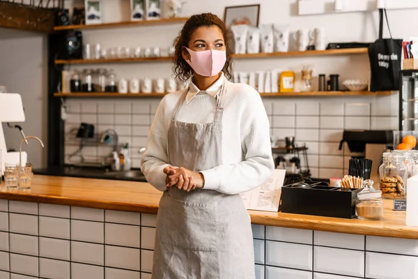 Jeune Serveuse Noire Masquée Debout Près Comptoir Café Intérieur — Photo