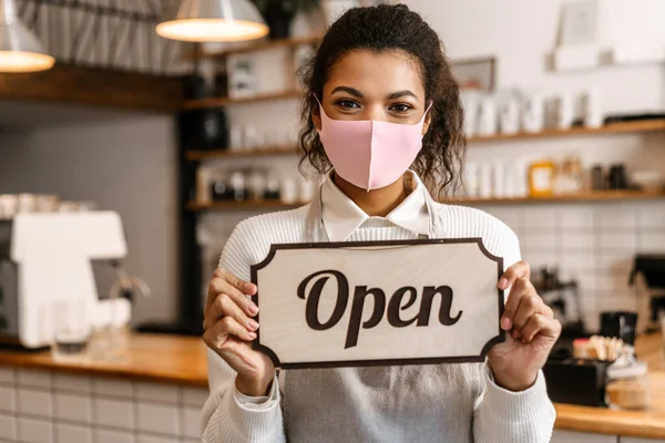 Young Black Waitress Face Mask Showing Open Sign Board Cafe — Stock Photo, Image