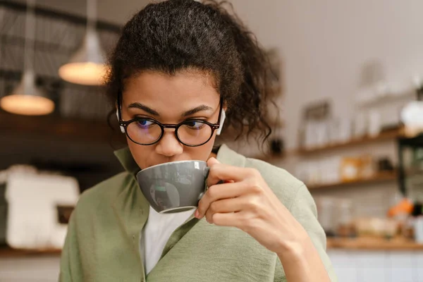 Черная Женщина Слушает Музыку Наушниками Время Питья Кофе Кафе Помещении — стоковое фото