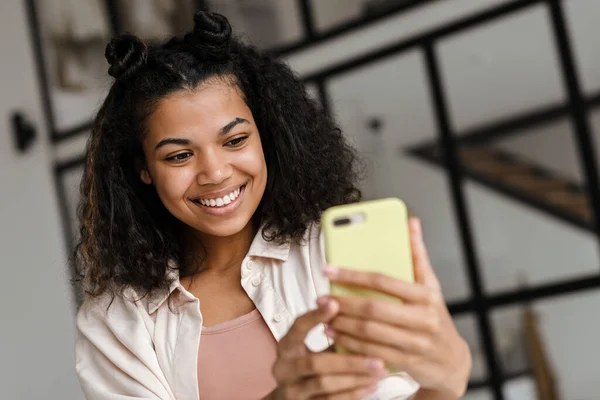 Ung Lykkelig Amerikansk Kvinne Med Smarttelefon Som Lager Blogg Hjemmefra – stockfoto
