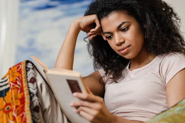 黒若いです女性読書本を読みながら自宅で休む — ストック写真
